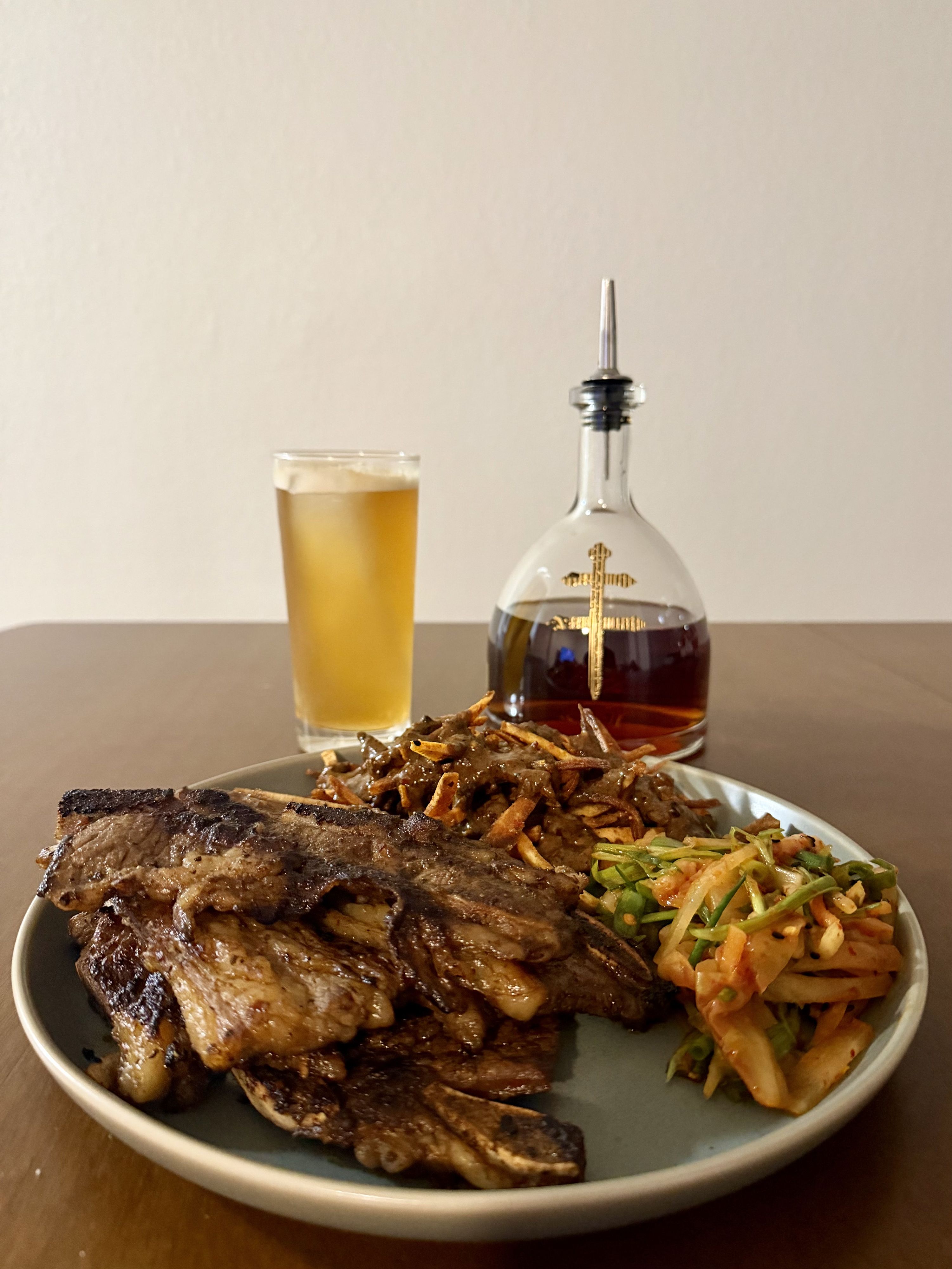Closer shot of the galbi frites plate with a beer and decanter