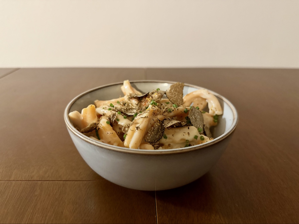 Close-up of mac and cheese with shaved truffle and chopped chives